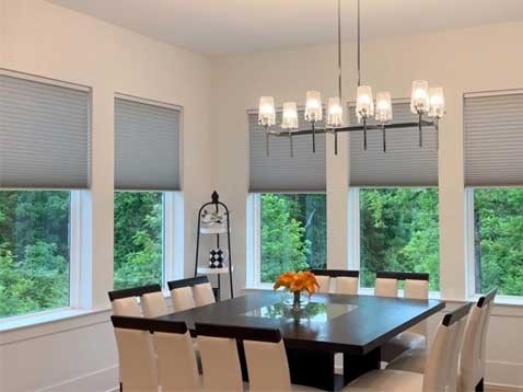 Kitchen with hanging lights and honeycomb shades